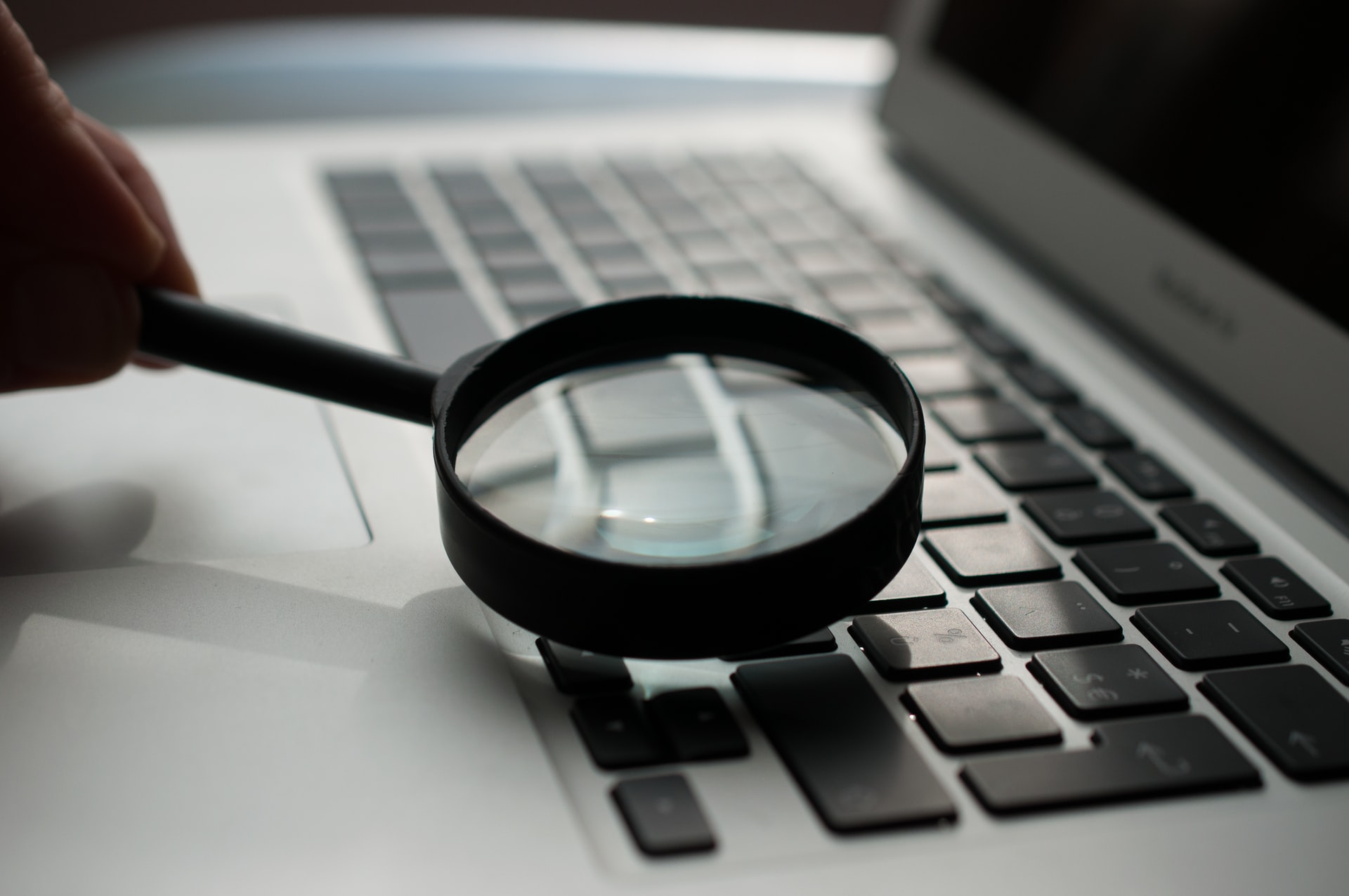 A magnifying glass pointed at a laptop keyboard